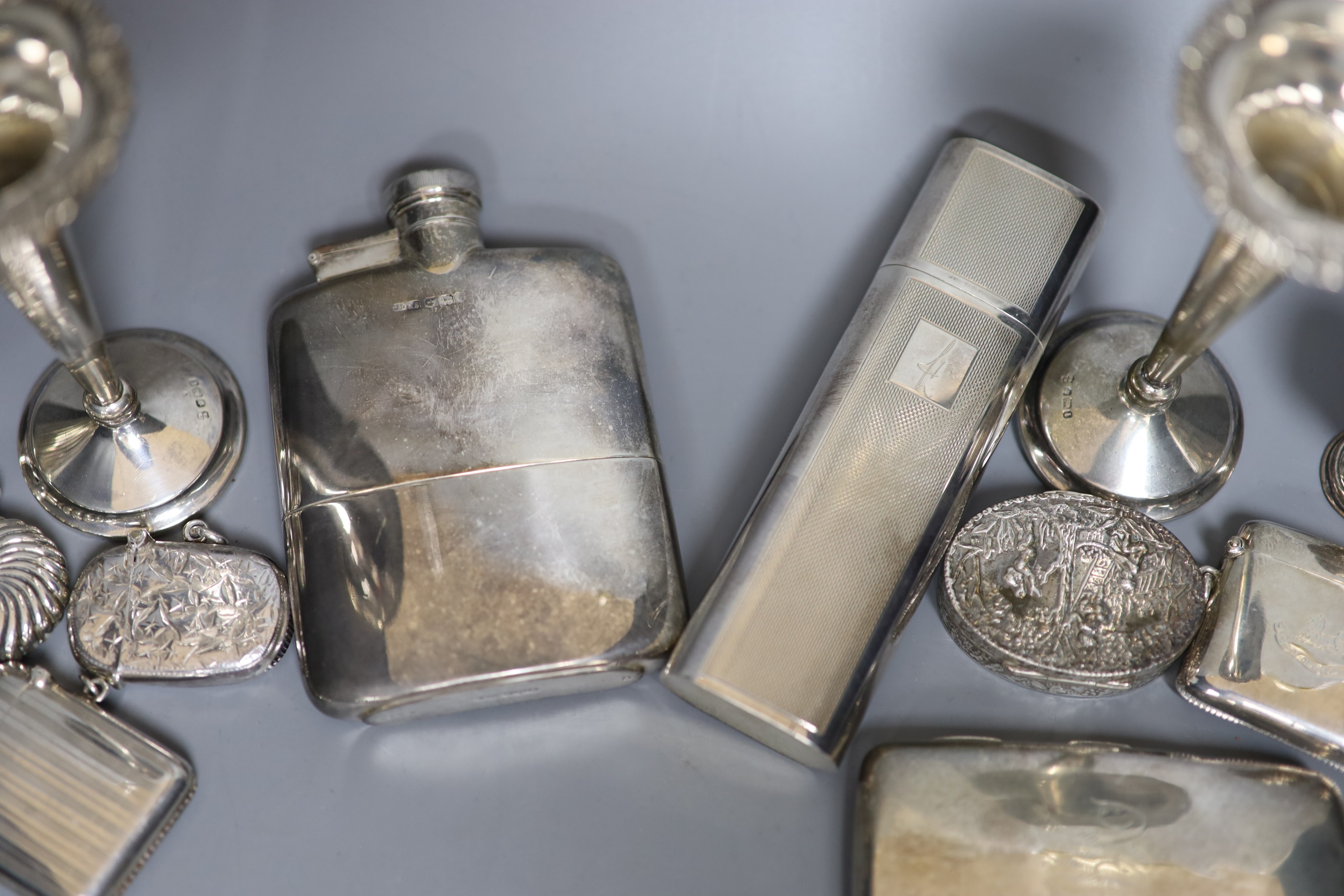 A group of assorted silver including two hip flasks, two spill vases, condiments, vesta cases, cigarette case, scent flask etc.